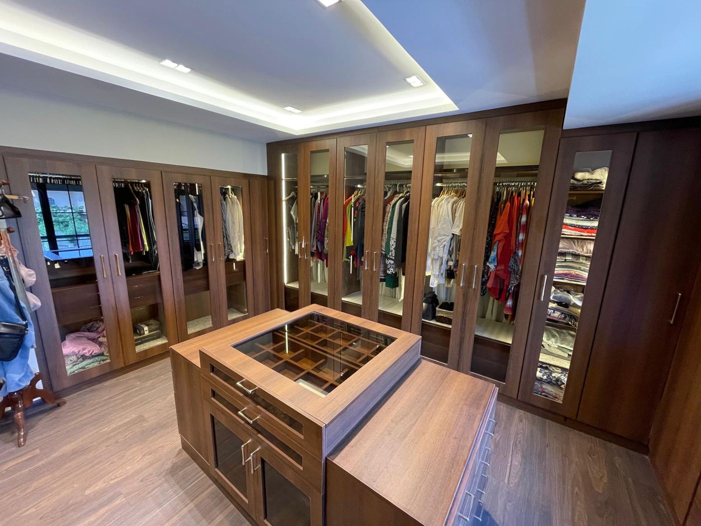 Walk-in dressing room with lit glass wardrobes
