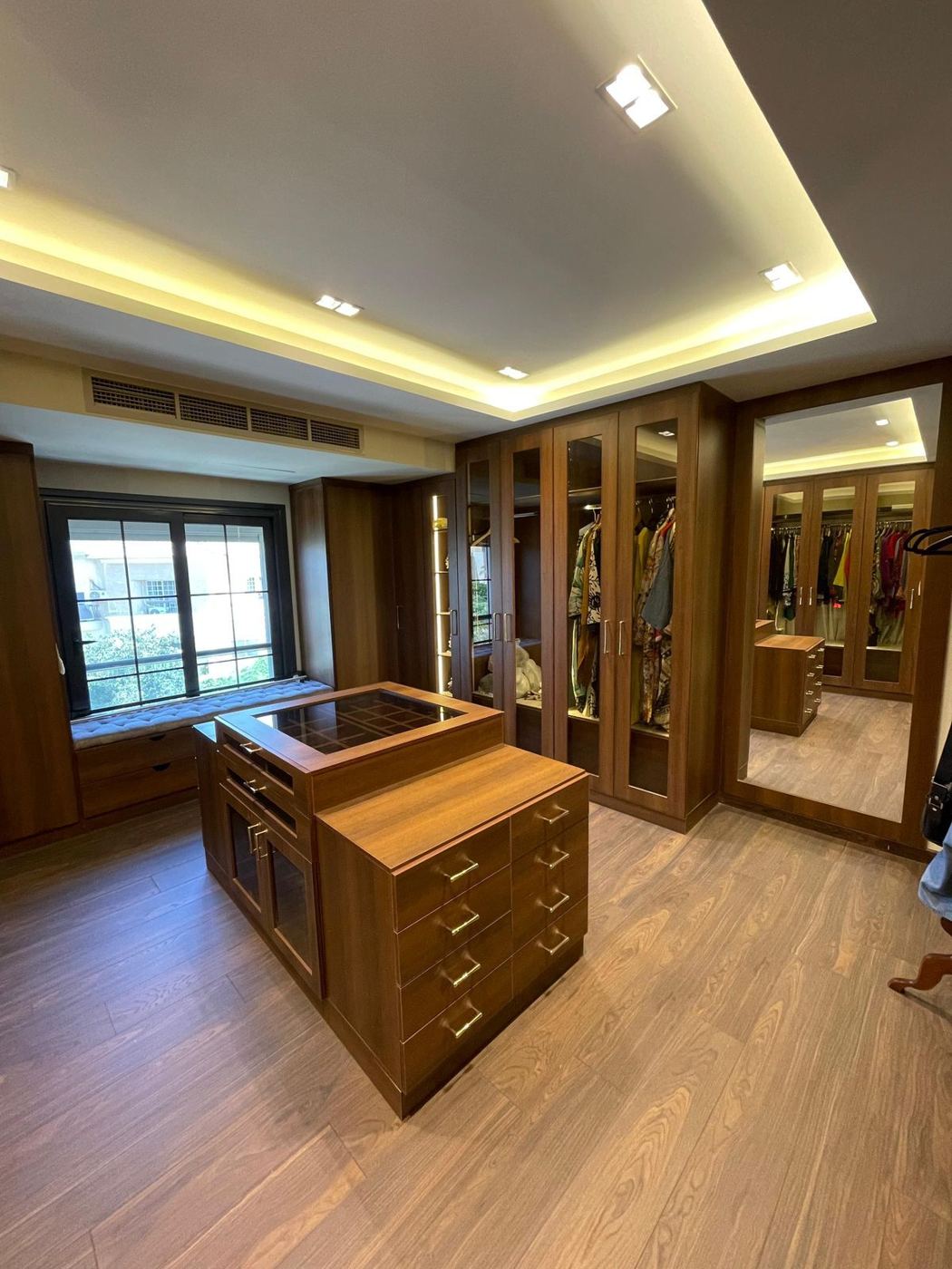 Dressing room with island and lit ceiling