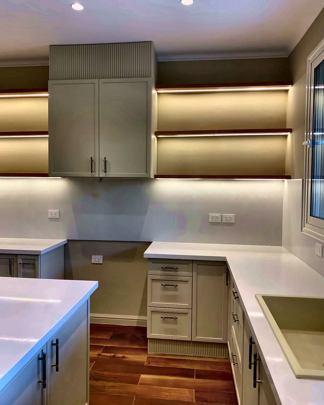 Fluted wall cabinet between LED-lit wooden shelves, New Giza